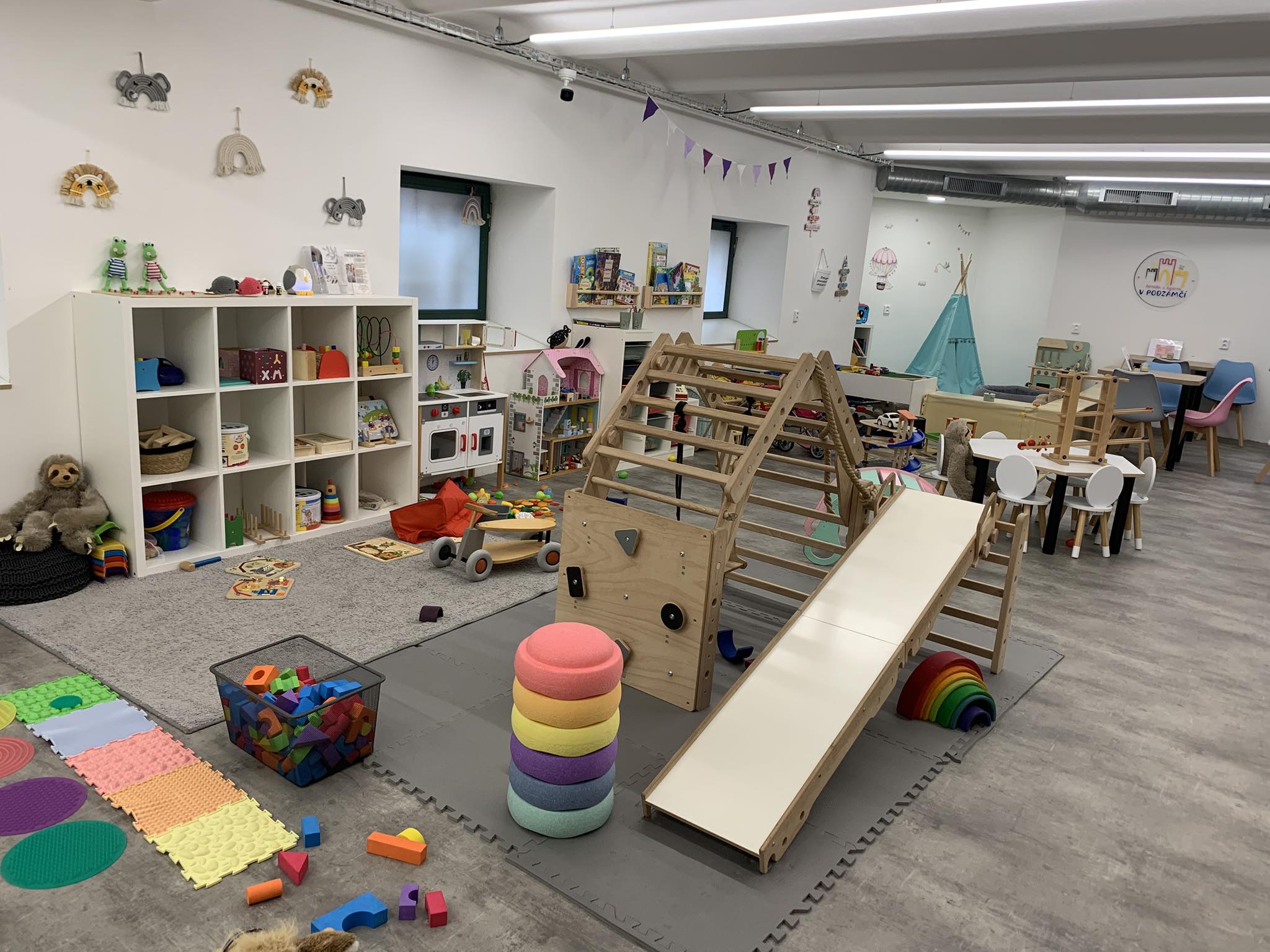 Pohled do herničky — prolézačka, kostky a hrací koutky